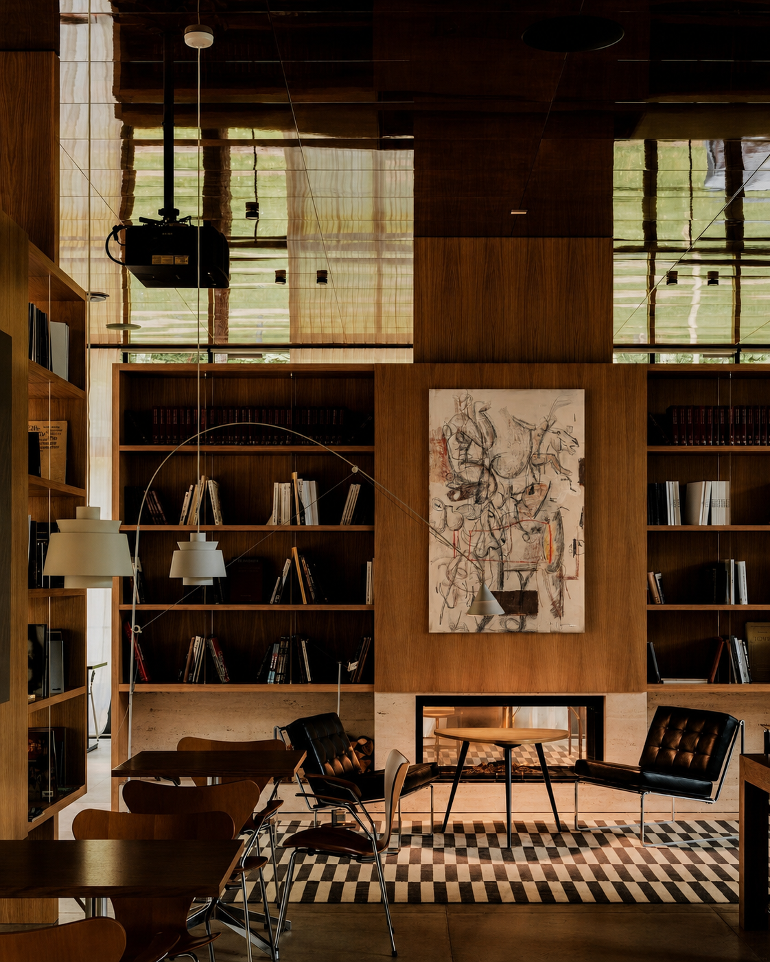 Modern interior with bookshelves, chairs, and a map artwork on a wall.
