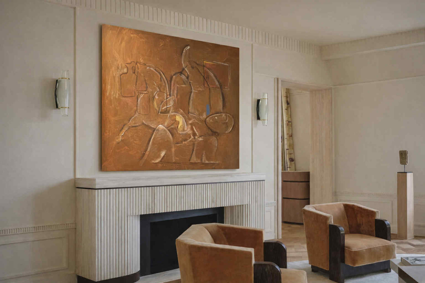 Living room with a large bronze sculpture above a fireplace